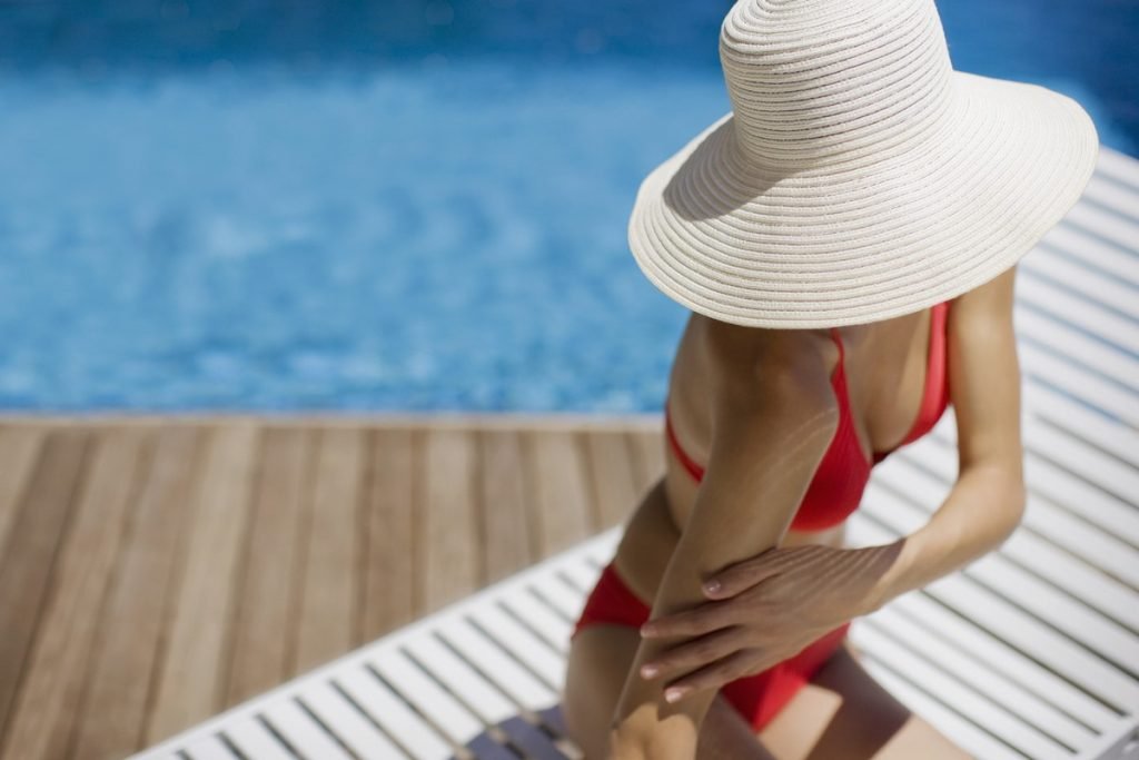 Mulher de chapéu na piscina