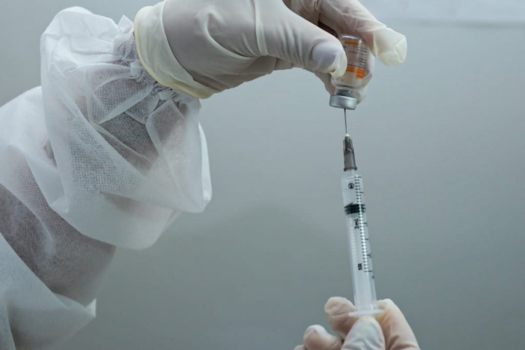 Enfermeira prepara dose da vacina contra Covid-19 para imunizar idosa, em Goiânia