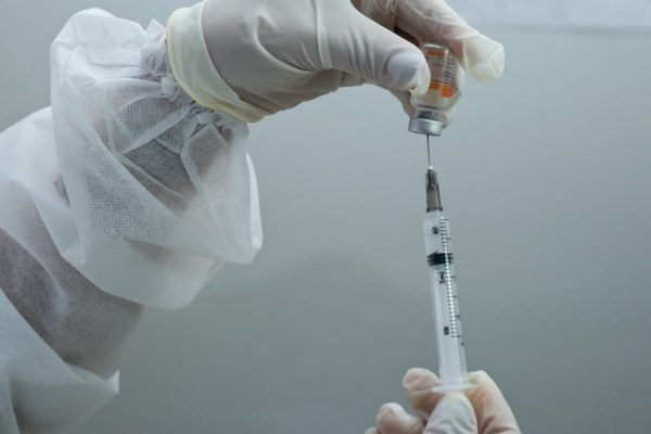 Enfermeira prepara dose da vacina contra Covid-19 para imunizar idosa, em Goiânia