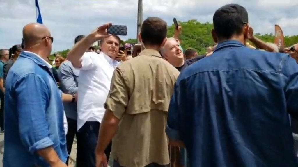 Presidente Jair Bolsonaro faz selfie com apoiador, em São Francisco do Sul (SC)