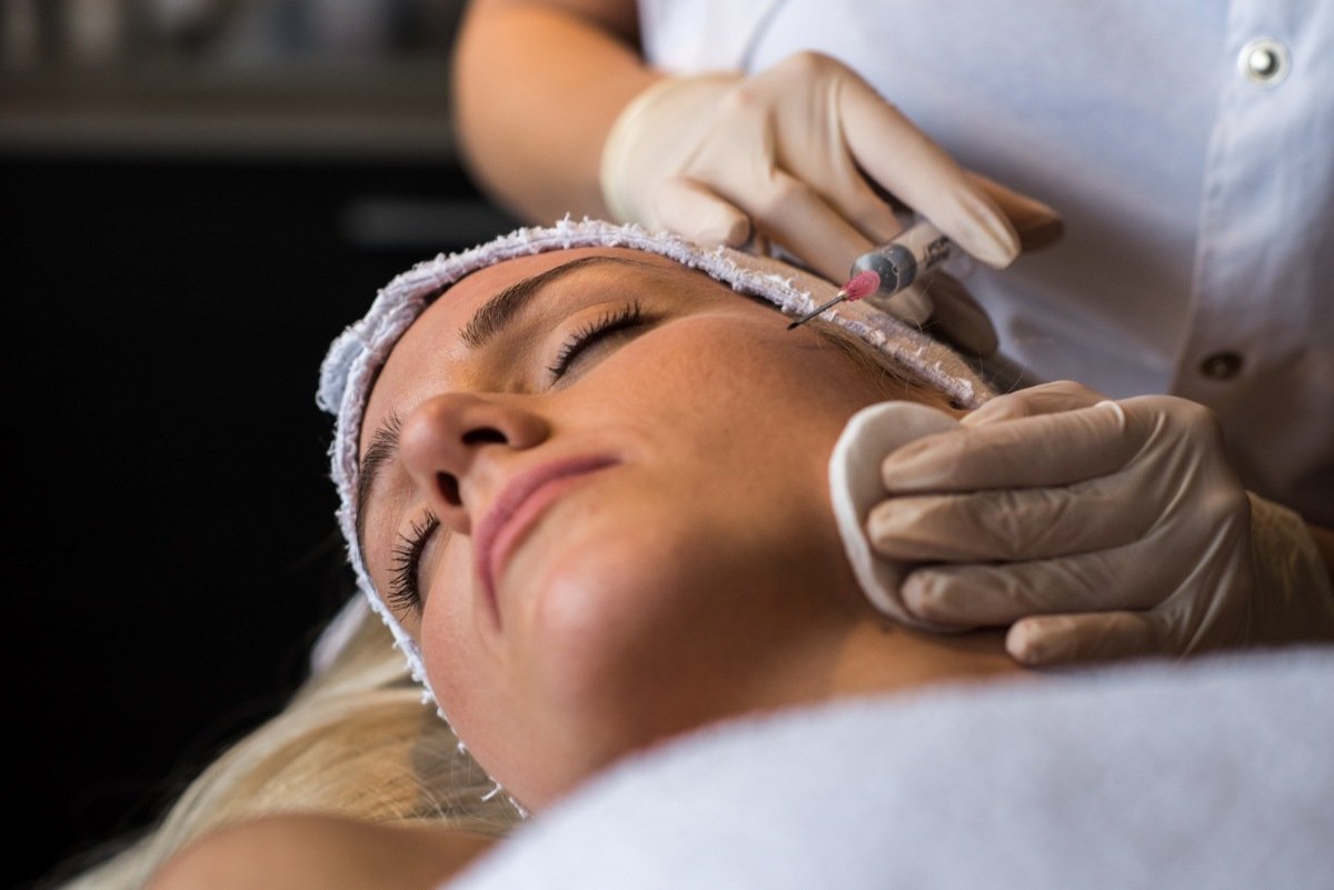 mulher deitada recebendo injeção de botox