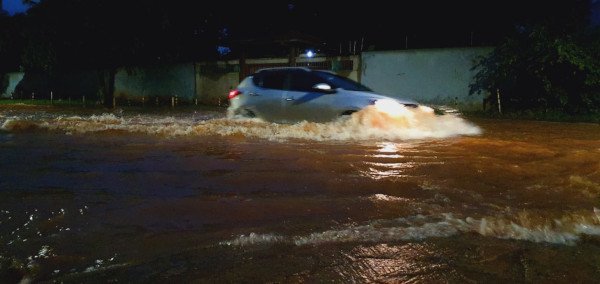 Carros passando por via inundada