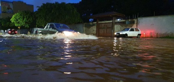 Carros passando por via inundada