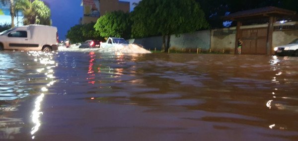 Carros passando por via inundada