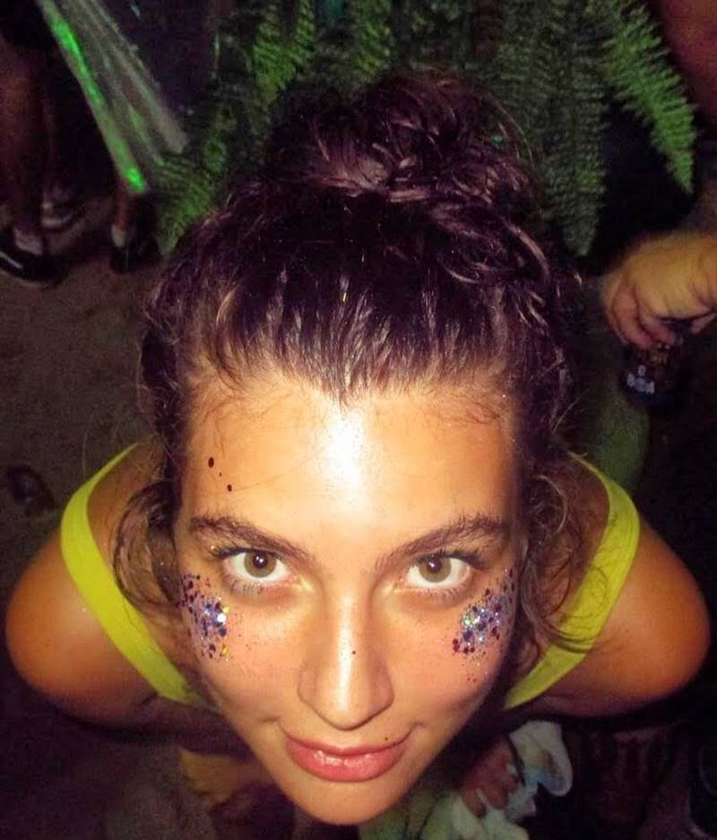 Foto colorida de Alanis Guillen com os cabelos presos, olhando para cima com glitter no rosto - Metrópoles