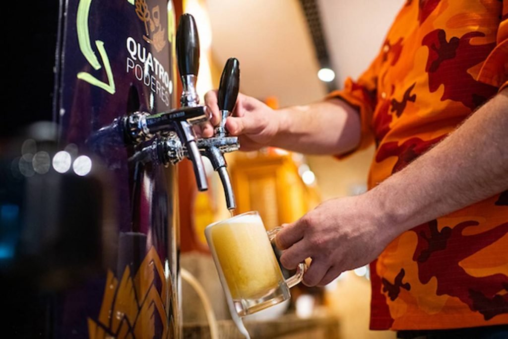 Mão colocando chope direto da torneira
