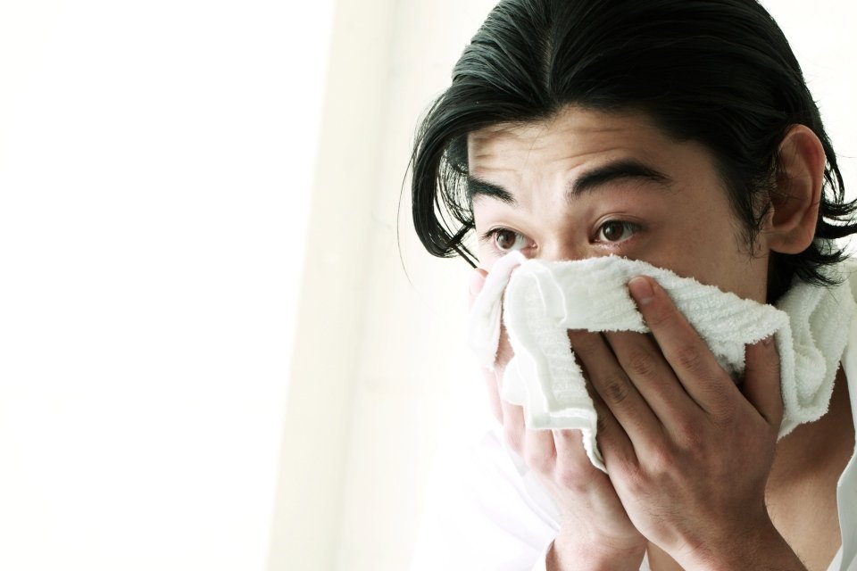 homem usando toalha no rosto