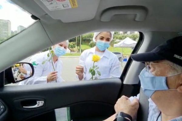 Idoso presenteia enfermeiras com flores antes de ser vacinado contra a Covid-19