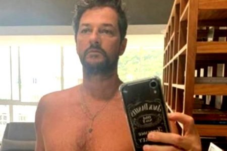 Marcelo Serrado posando sem camisa em frente ao espelho