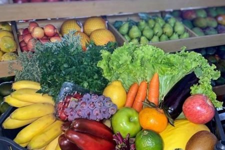 Cesta com frutas e verduras como banana, alface, cenoura, uva, pimentão e outros produtos