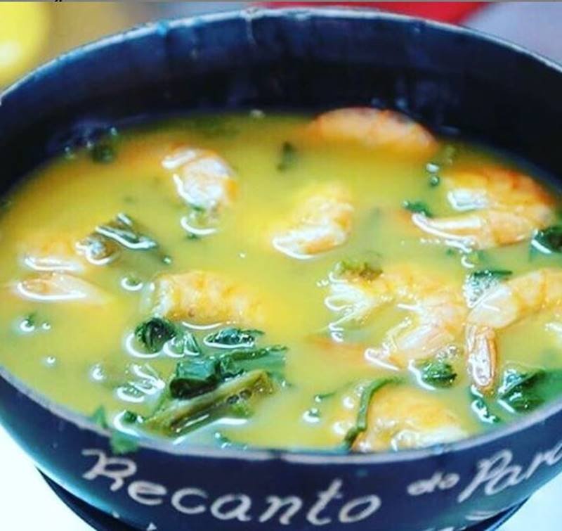 Cumbuca com camarões dentro de um caldo amarelo