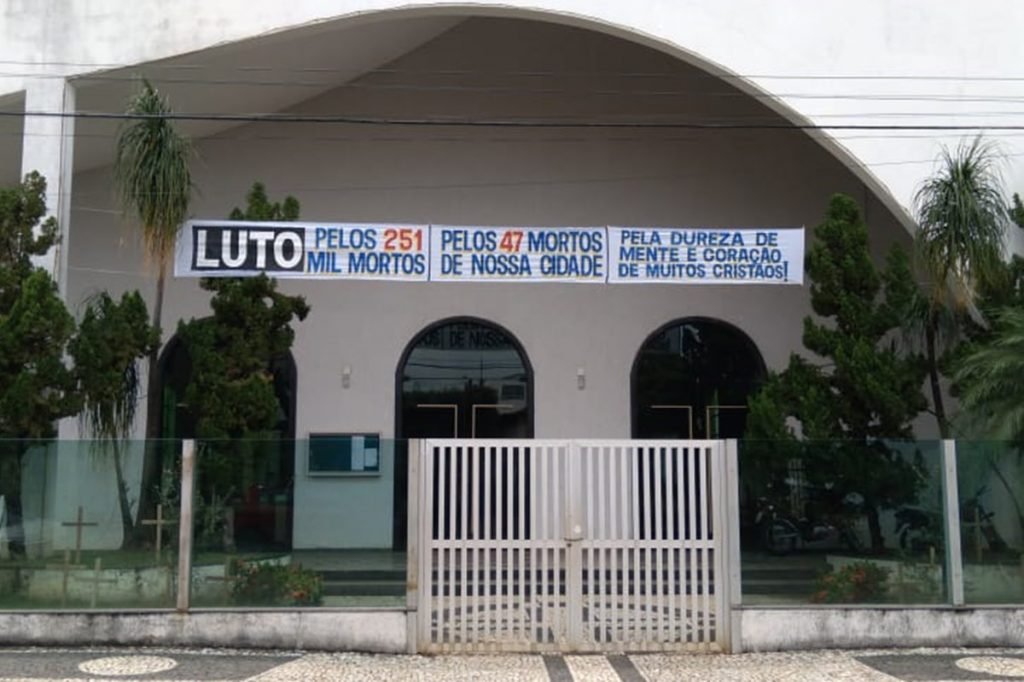 Padre colocou faixa de luto pelas mortes ocasionadas pela pandemia da Covid-19 na frente da igreja Cristo Redentor, em Itapuranga Goiás