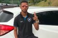 O volante do Botafogo, Caio Alexandre, ao lado do carro