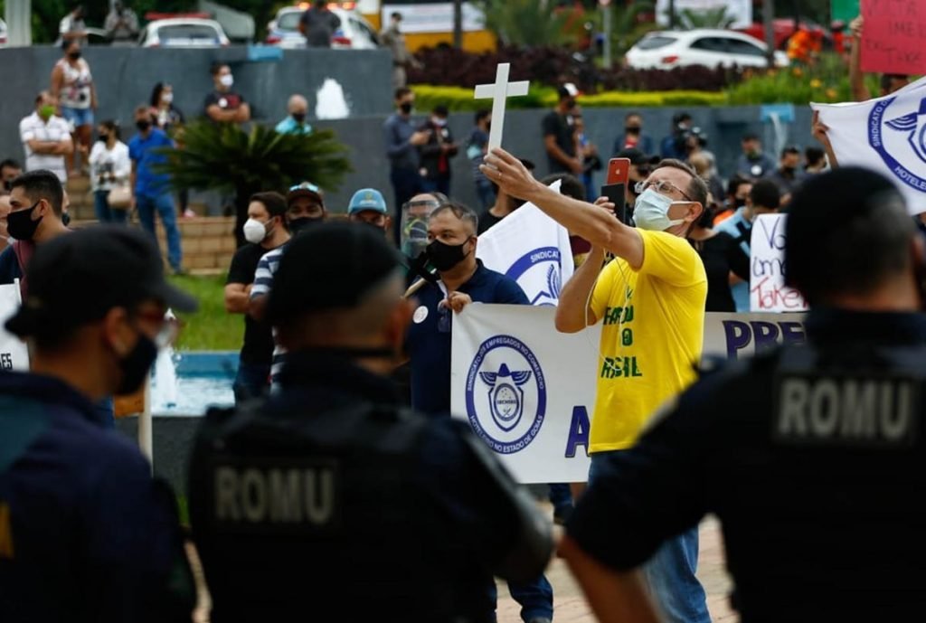 donos e funcionários de bares de goiânia, goiás, em protesto em frente a prefeitura, segurando cruzes e cartazes