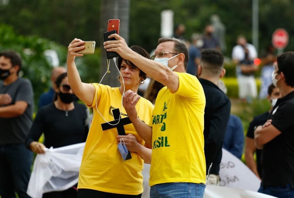 donos e funcionários de bares de goiânia, goiás, em protesto em frente a prefeitura, segurando cruzes e cartazes