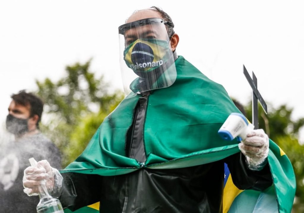donos e funcionários de bares de goiânia, goiás, em protesto em frente a prefeitura, segurando cruzes e cartazes
