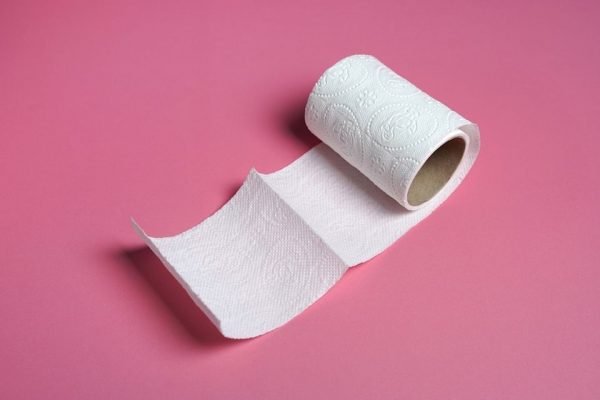 Imagem de papel higiênico sobre fundo rosa - Metrópoles