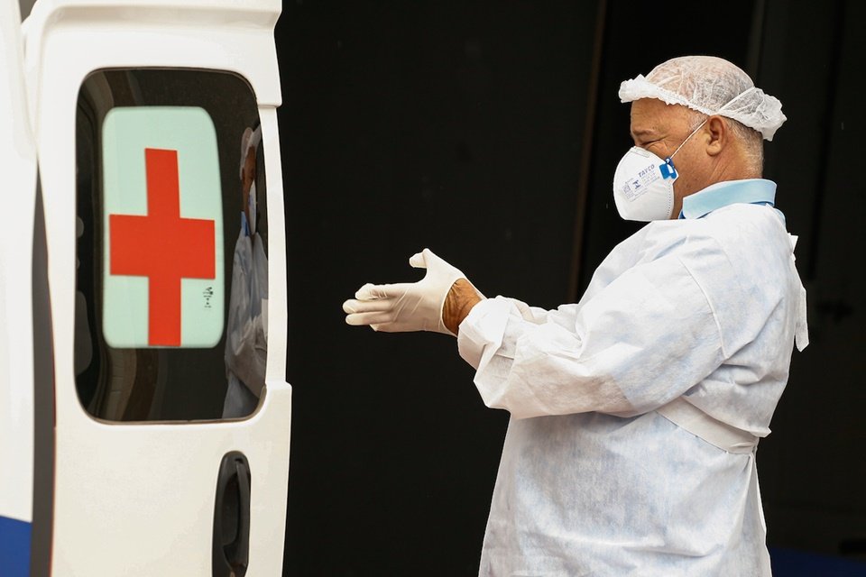 profissional de saúde tira luva em frente a hospital de goiânia