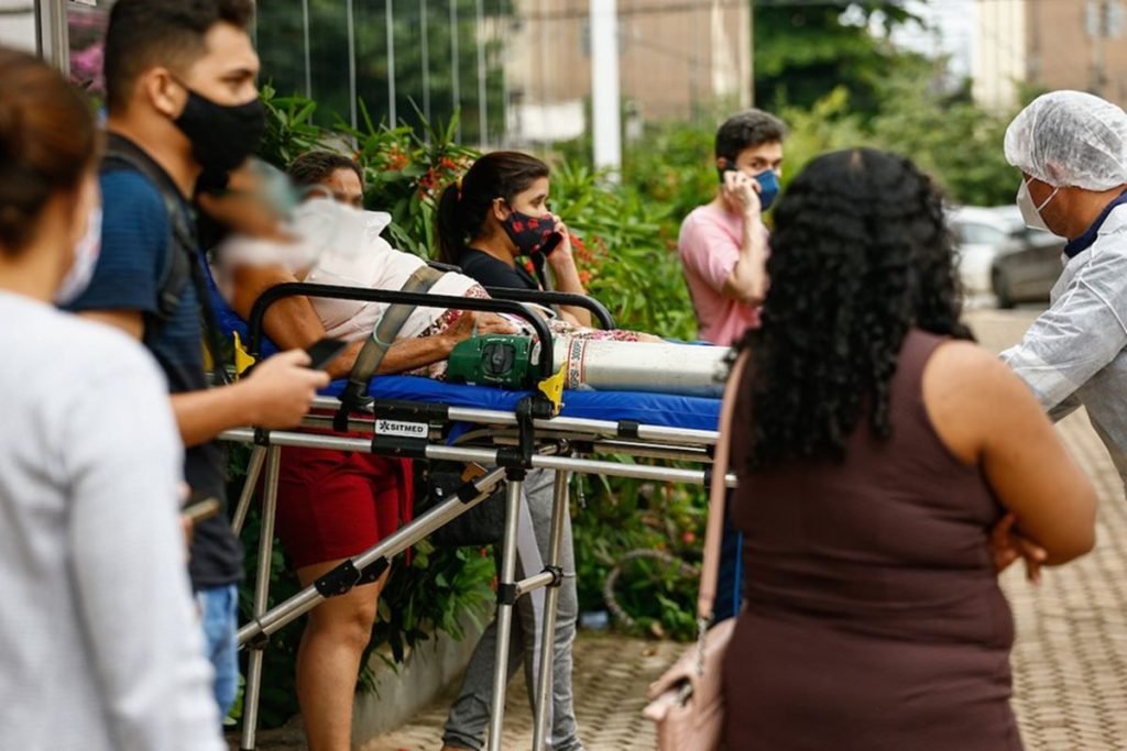 paciente é levada na maca, com covid-19, na porta de hospital de goiânia