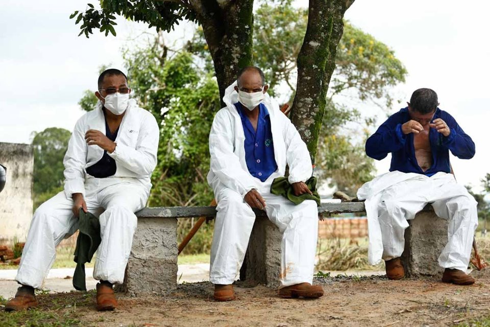 coveiros de cemitério municipal, em goiânia, goiás, enterram vítima de covid-19. rotina cansativa