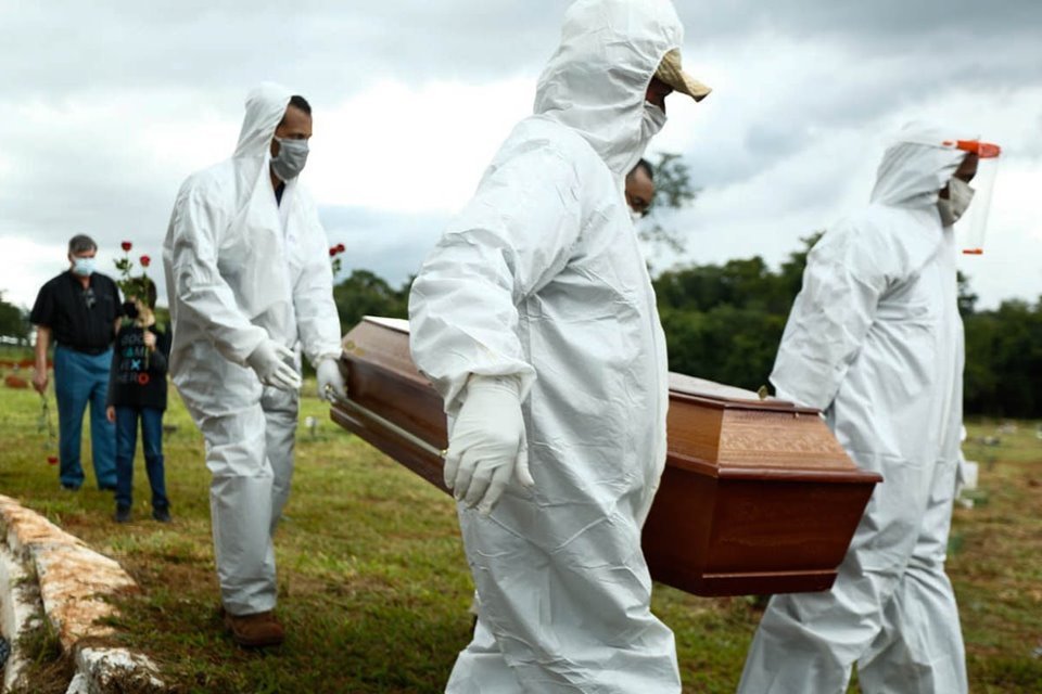 coveiros de cemitério municipal, em goiânia, goiás, enterram vítima de covid-19. rotina cansativa