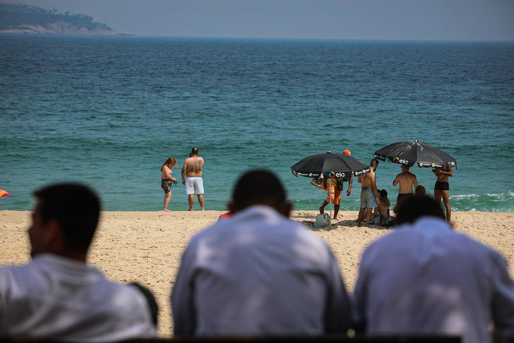 Cariocas e turistas ignoram medidas restritivas e permanecem nas areias das praias do Rio