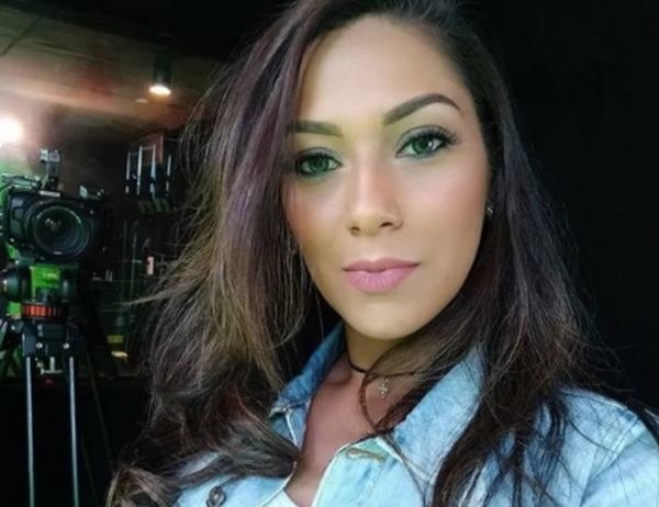 mulher de cabelo preto, maquiada e com uma blusa azul