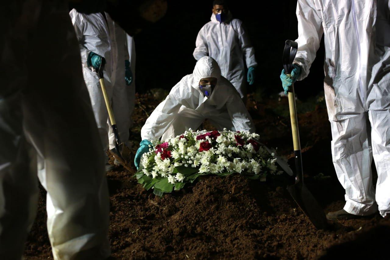 Sepultadores enterram à noite corpo de vítima de Covid-19 no Cemitério da Vila Formosa, em São Paulo