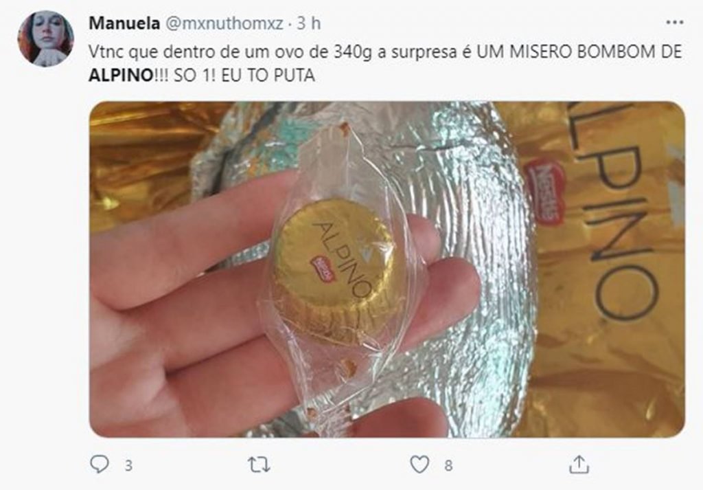 Tuíte escrito: Dentro de um ovo de 340g a surpresa é um mísero bombom de Alpino! Só um! Eun tô puta! e uma foto mostrando um bombom