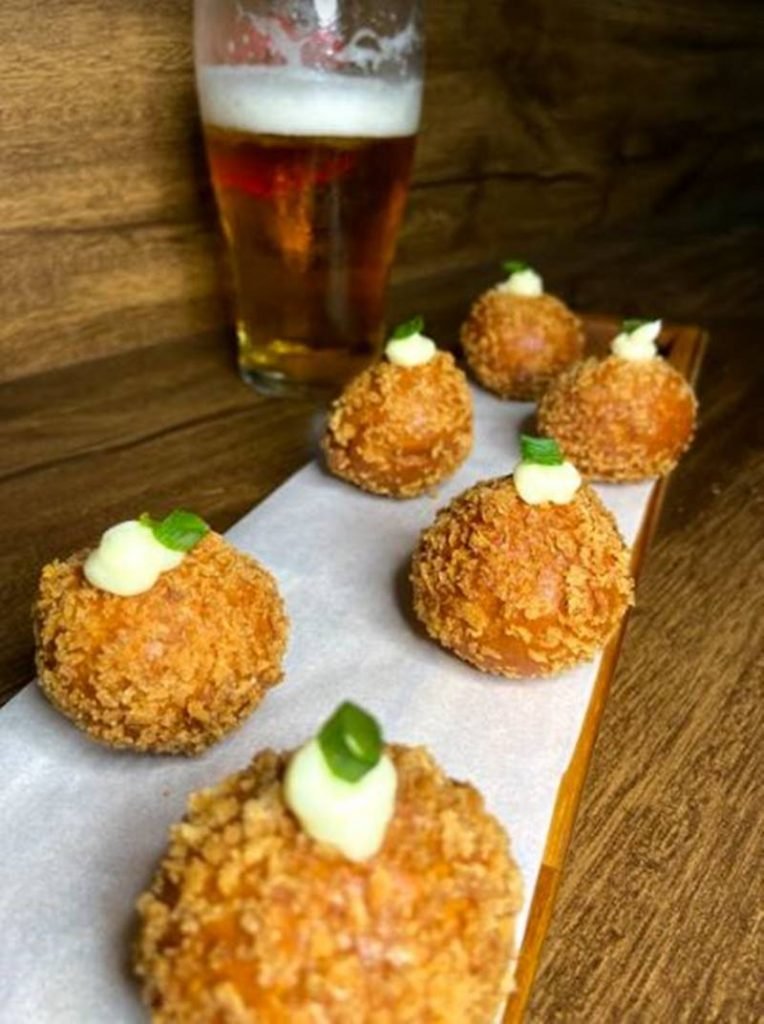 Na foto, bolinhos fritos e copo de cerveja - Metrópoles
