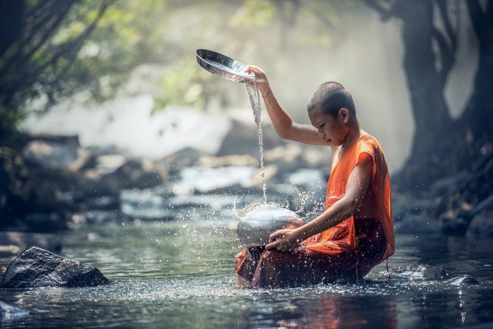 menino monge rio budista agua