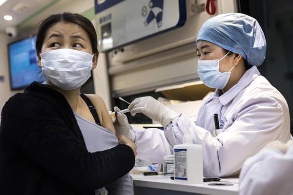 Mulher chinesa sendo vacinada