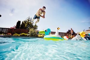 homem pulando em piscina