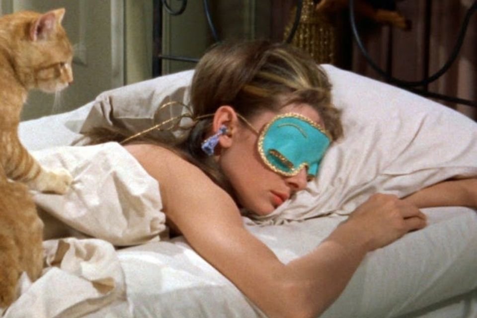 Imagem do filme Bonequinha de Luxo mostra a atriz Audrey Hepburn dormindo com máscara nos olhos - Metrópoles