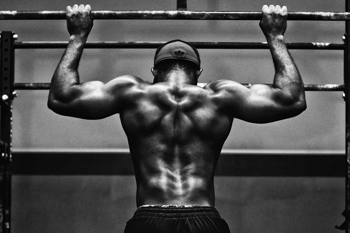 foto em preto e branco de homem fazendo uma barra com as costas bem definidas - Metrópoles