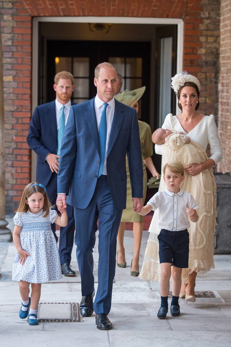 Princesa Charlotte, William, George, Kate Middleton e Louis. Atrás, príncipe Harry e Meghan Markle