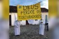 homens vestindo branco, roupas semelhante a da ku klux klan manifestando favorável à tortura na cidade de goiás