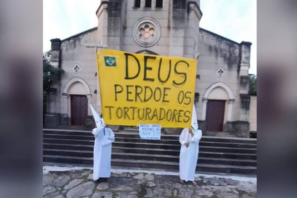 homens vestindo branco, roupas semelhante a da ku klux klan manifestando favorável à tortura na cidade de goiás