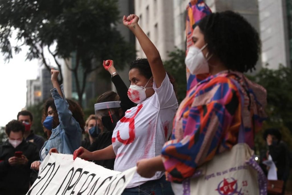 Manifestantes seguram faixa em ato que homenageia mortos em Jacarezinho
