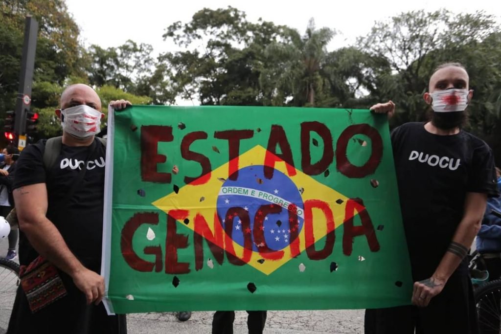Manifestantes com faixa Estado FGenocida
