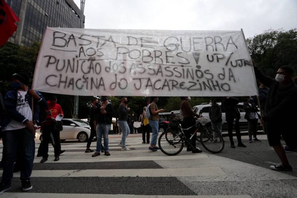 manifestantes com faixa que pede fim da guerra aos pobres