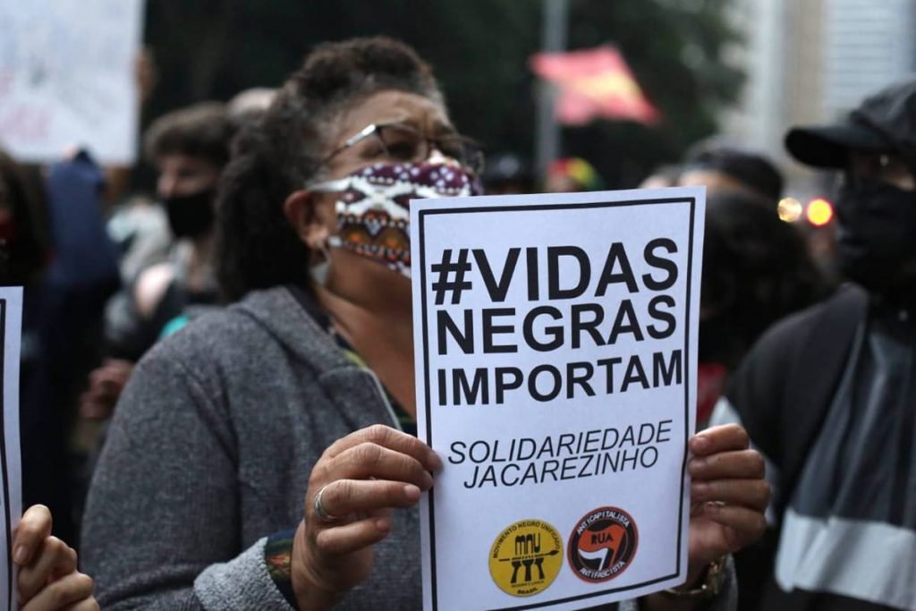 Manifestante com cartaz Vidas Negras importam
