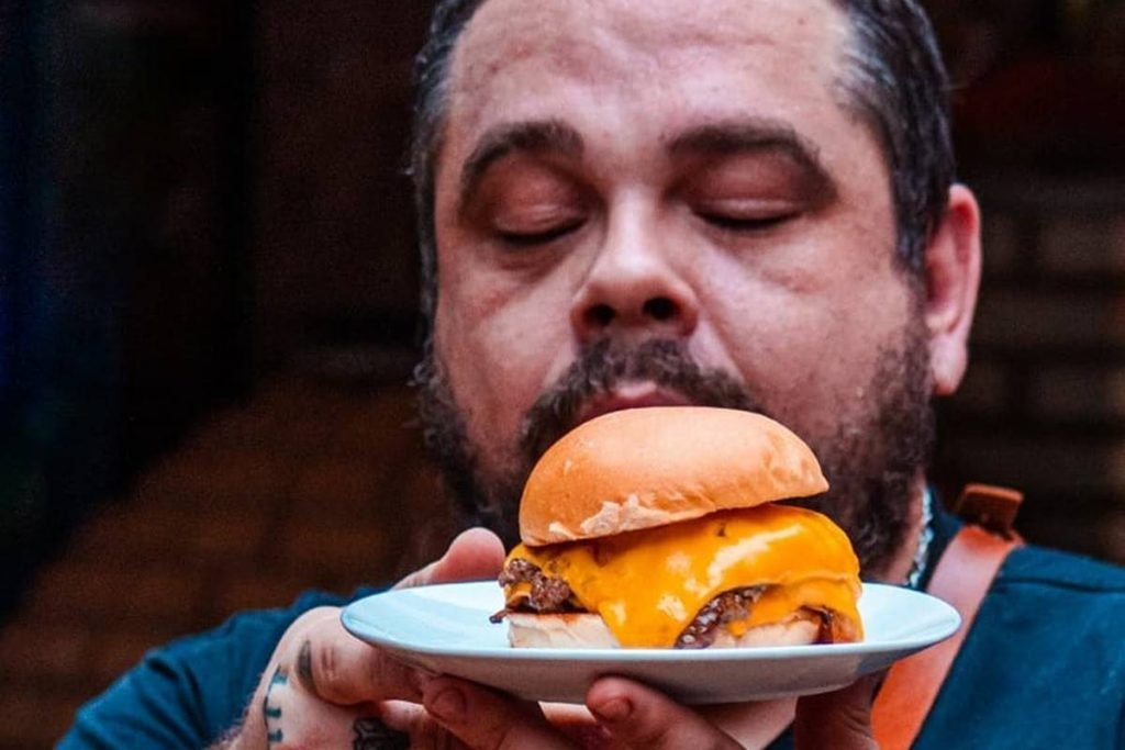 Bruno Curuja segurando hambúrguer