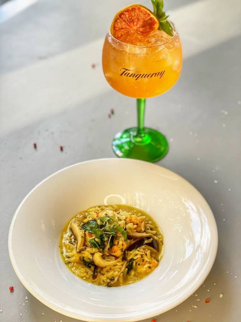 Prato com risoni e drinque ao fundo