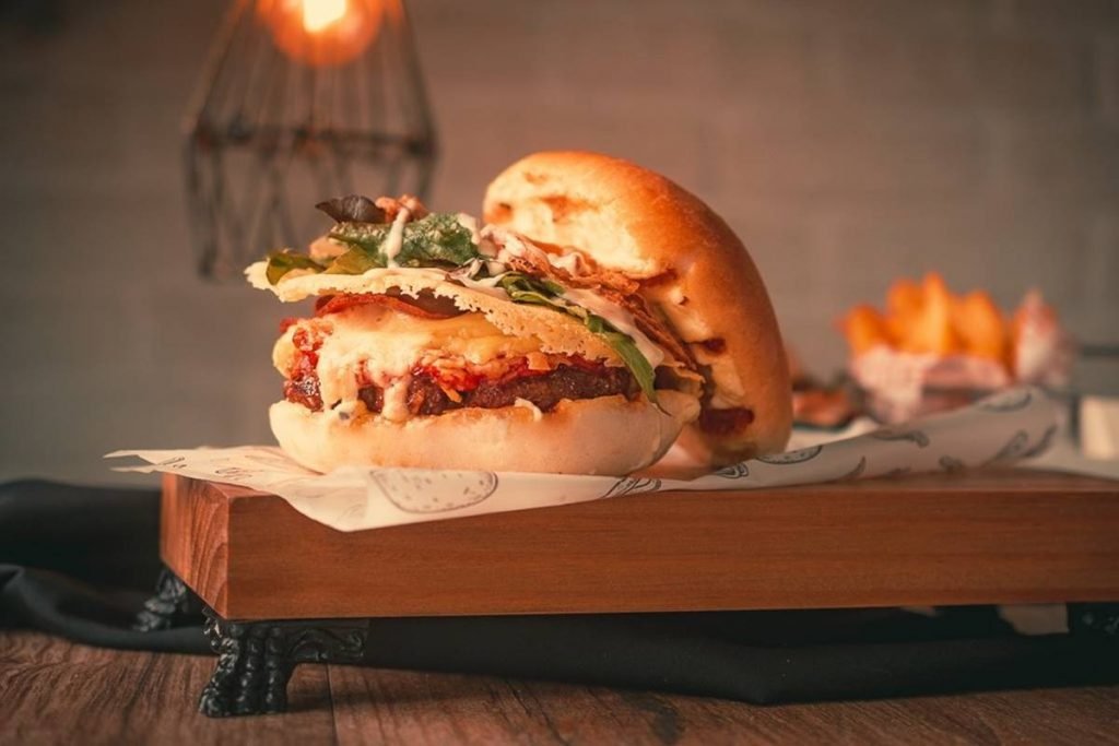 hamburguer aberto em cima de tabua de madeira