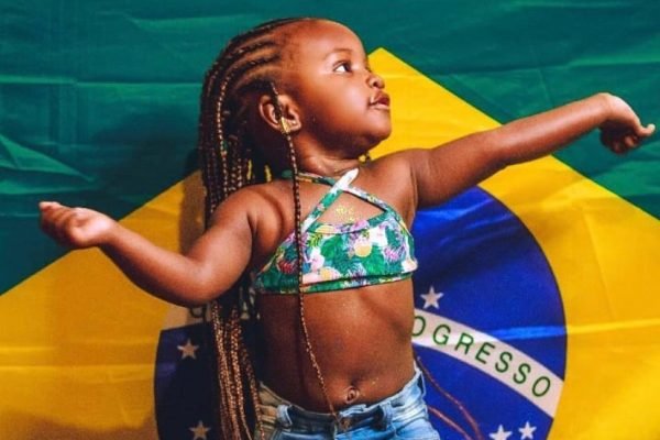 criança com bandeira do Brasil ao fundo