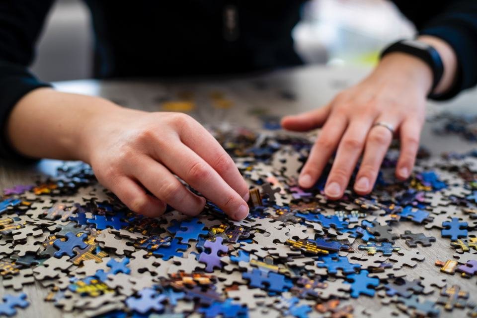 Farbfoto einer Person, die ein Puzzle zusammenbaut