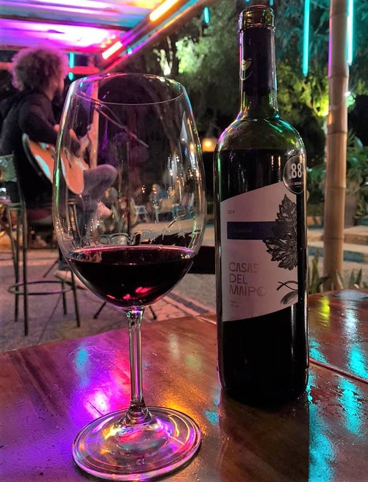 Garrafa e taça de vinho com cantor de fundo
