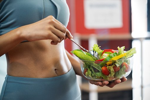 Mulher comendo salada