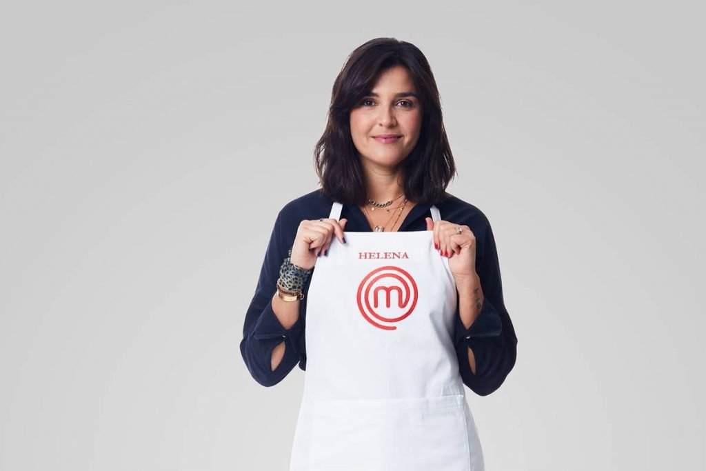 Mulher sorri segurando avental do masterchef